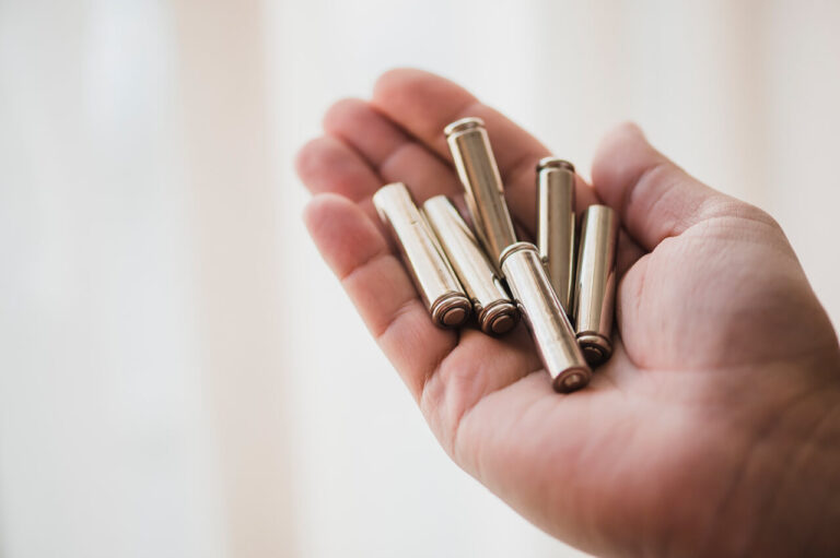 Close up of a hand holding empty gun shells